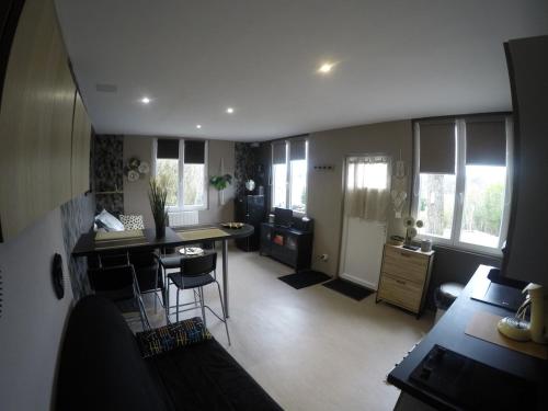 une cuisine et un salon avec une table et des chaises dans l'établissement Le refuge du lac, à Changey