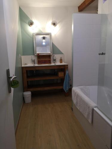 une salle de bain avec un lavabo, un miroir et une baignoire dans l'établissement House in Allevard-les-Bains, à Allevard