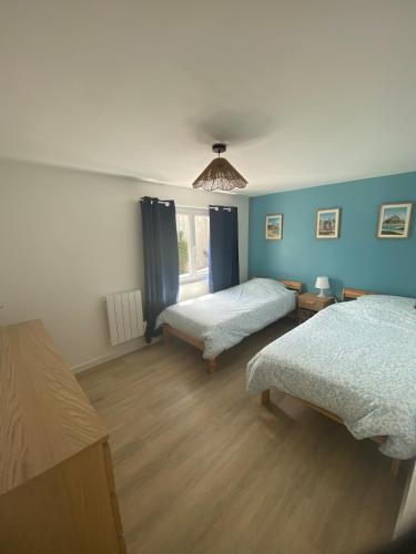 Ce lit se trouve dans un dortoir doté de murs bleus et de parquet. dans l'établissement Maison cosy à Aure sur Mer, à Sainte-Honorine-des-Pertes