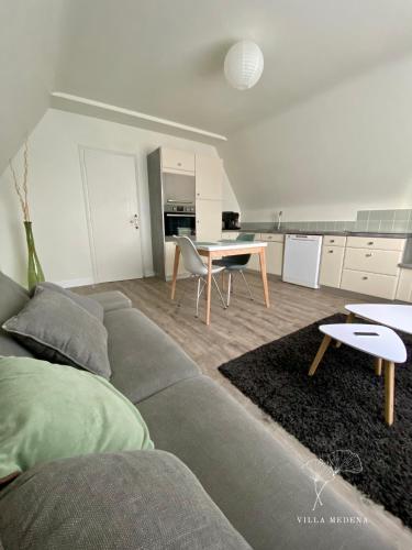 a living room with a couch and a table at Appartement Villa Medena - Classé 3 étoiles in Mayenne