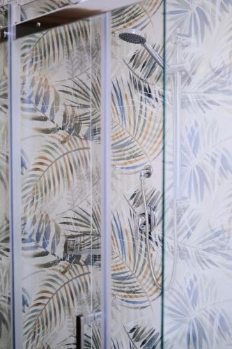 a shower stall with a mural of a plant at Bassa Marea in Chioggia