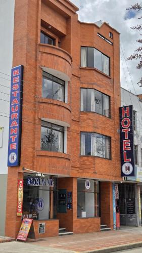 a brick building with a sign in front of it at Hotel Imperial in Chiquinquirá