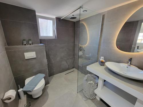 un bagno con doccia, WC e lavandino di Golden Rays Suites a Sarandë