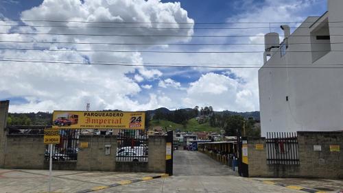 a sign on a fence in a parking lot at Hotel Imperial in Chiquinquirá