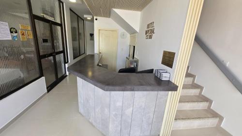 a lobby with a counter and stairs in a building at Hotel Imperial in Chiquinquirá