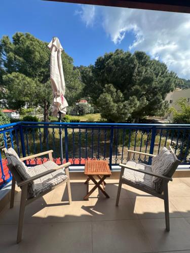a patio with two chairs and a table on a balcony at Katalyma Thalassa in Ixia