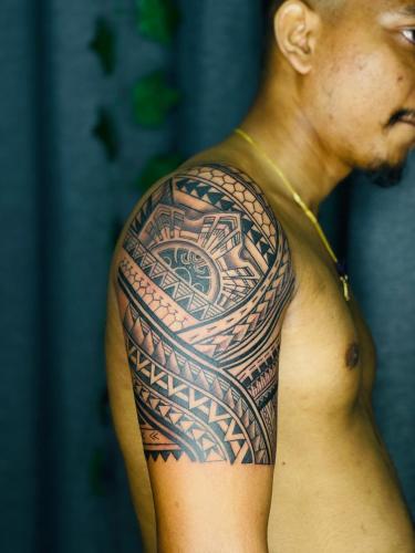 a man with a traditional tattoo on his arm at Dream Tattoos in Weligama