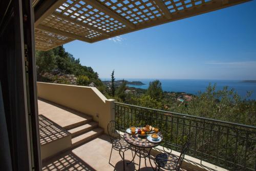 a balcony with a table and chairs and the ocean at Ionian Vista Villas in Argostoli
