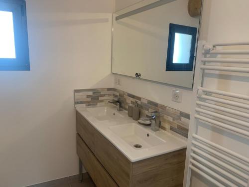 une salle de bain avec un lavabo et un miroir dans l'établissement Maison rénovée 3 chambres, à Mollégès
