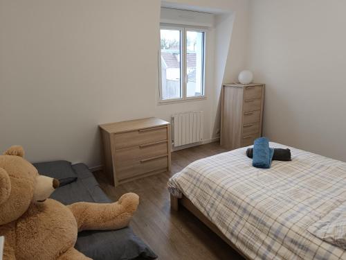 - une chambre avec un lit et un ours en peluche dans l'établissement Appartement F1, à Saint-Rémy-lès-Chevreuse