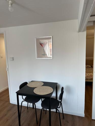 a black table and two chairs in a room at Laundry Studio 2 - proche gare- centre ville- CNPE in Calais