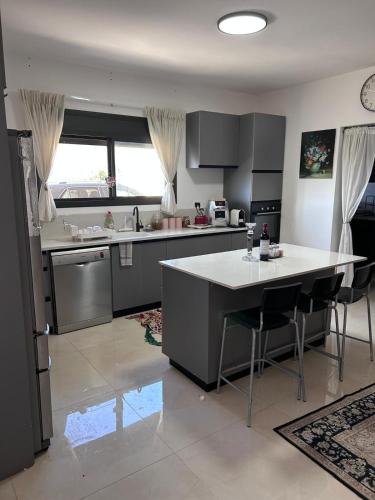 a kitchen with a island in the middle of a room at הבית על ההר בכרמל in ‘Isfiyā