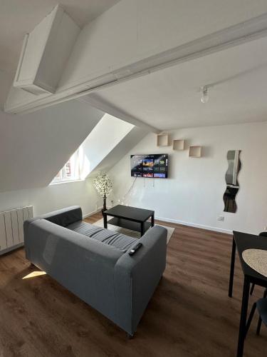 a living room with a couch and a table at Laundry Studio 2 - proche gare- centre ville- CNPE in Calais