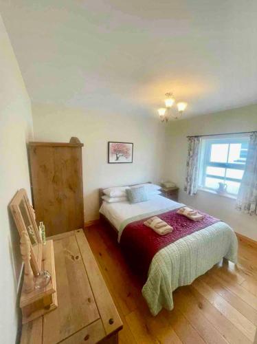 a bedroom with a bed and a window at Carraig Ban Cottage Dungloe in Ardeevin