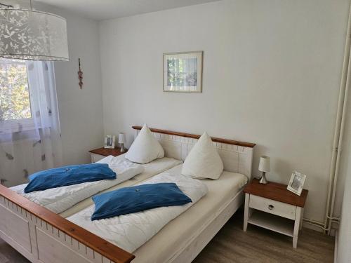 two beds in a room with blue pillows on them at Strandnahe FeWo Sonneneck auf Poel mit Garten & Stellplatz in Insel Poel