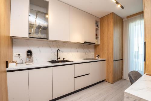 a kitchen with white cabinets and a sink at Studio President 80 in Craiova
