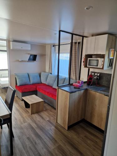 - un salon avec un canapé rouge dans l'établissement Mobil Home tout equipé Camping Siblu 4etoiles Les Charmettes, aux Mathes