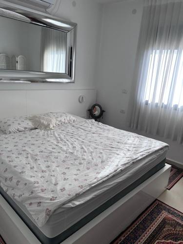 a bed in a bedroom with a mirror on the wall at הבית על ההר בכרמל in ‘Isfiyā