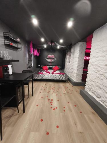 Cette chambre dispose d'un lit et d'une table avec des fleurs rouges. dans l'établissement Romantic Room proche de Paris, à Choisy-le-Roi