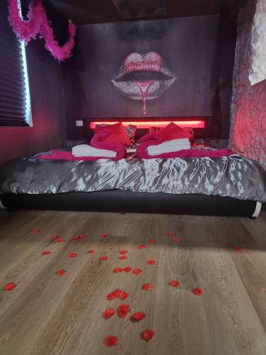 1 dormitorio con 1 cama con flores rojas en el suelo en Romantic Room proche de Paris, en Choisy-le-Roi
