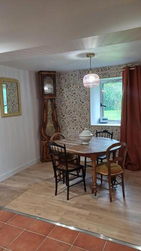 une salle à manger avec une table et des chaises en bois dans l'établissement O'Pix Cottage, à Montreuil-le-Henri