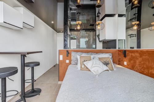 une chambre avec un lit avec des oreillers et un bar dans l'établissement Cap cosy Heliopolis, au Cap d'Agde