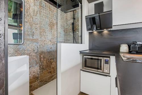 une petite cuisine avec un four à micro-ondes et un réfrigérateur dans l'établissement Cap cosy Heliopolis, au Cap d'Agde