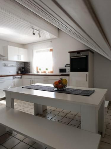 a kitchen with a table with a bowl of fruit on it at 65 qm Ferienwohnung im Grünen in Albbruck