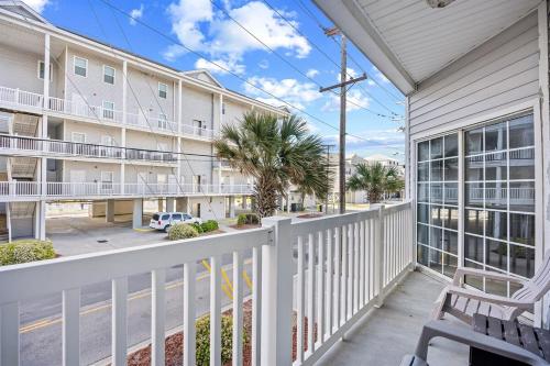 a balcony with a bench and a building at Pier Watch Unit 106-10 beds-6 bedrooms-Sleep14-Golf Cart Allowed in North Myrtle Beach