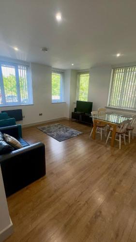 a living room with a couch and a table at Spacious 2 Bedroom Flat City Centre in Cannock