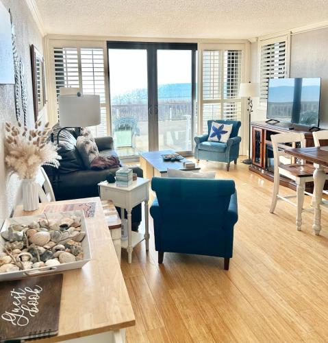 a living room with a couch and a table at The Salty Breeze - 2 Ocean Front Master's - Steps to the Beach in Myrtle Beach