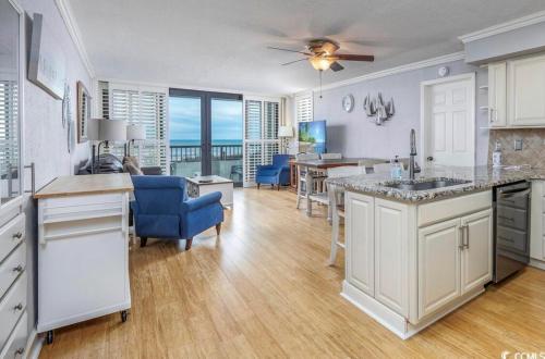 a kitchen and living room with a view of the ocean at The Salty Breeze - 2 Ocean Front Master's - Steps to the Beach in Myrtle Beach