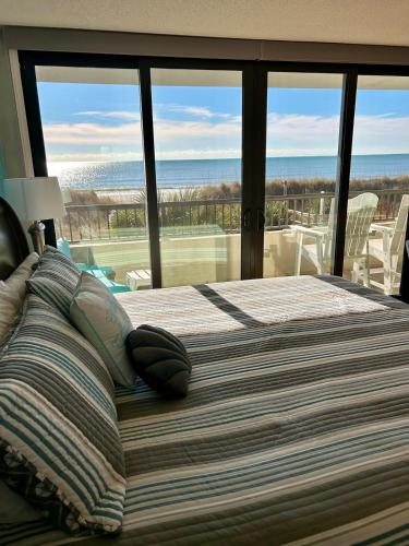 a bedroom with a bed with a view of the ocean at The Salty Breeze - 2 Ocean Front Master's - Steps to the Beach in Myrtle Beach
