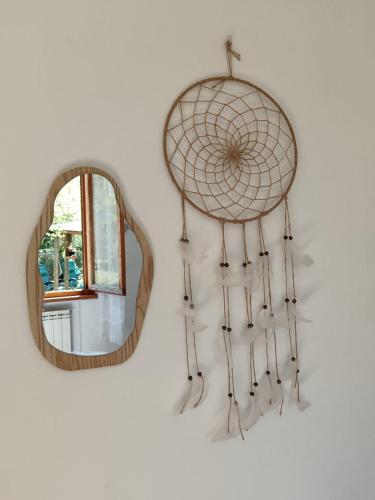 a mirror and a dream catcher hanging on a wall at Camere nel bosco sulla Via Francigena in Monteriggioni