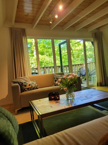 a living room with a couch and a table at A Wood Lodge - zwembad - relax - natuur in Durbuy