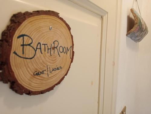 a wooden sign on a wall next to a door at Camere nel bosco sulla Via Francigena in Monteriggioni