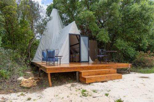 a tent with two chairs on a wooden deck at Aljezur Luxury Bedouin Tent in São Luis