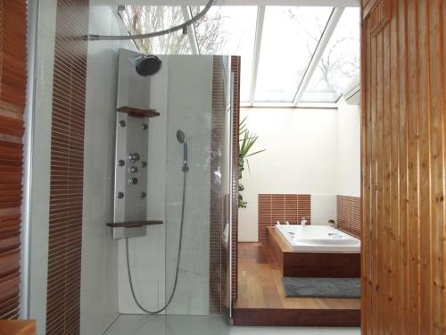 a bathroom with a shower and a tub and a sink at Gavial - Grande maison avec piscine in Léon