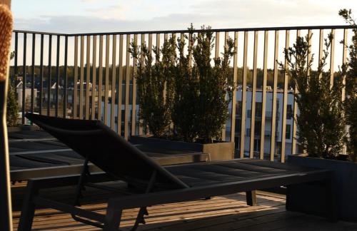 a chair sitting on top of a deck with plants at Seaside Stay in Palanga