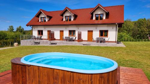 a large hot tub in front of a house at Compass House in Wisełka