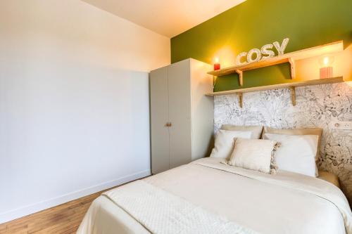 - une petite chambre avec un lit et un mur vert dans l'établissement L'Alma - Escapade d'Été à 15min de Paris & Versailles, à Garches