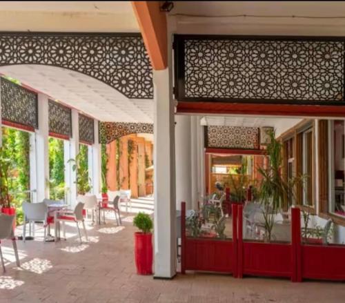 ein Restaurant mit einer Terrasse mit Tischen und Stühlen in der Unterkunft Riad De Luxe Marrakech in Marrakesch