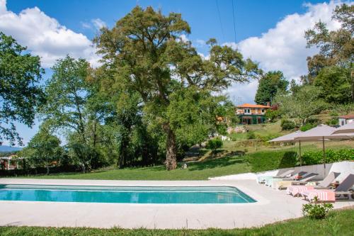 a swimming pool in front of a house at Just Like Home - Casa de São Sebastião em Cerveira in Linhares