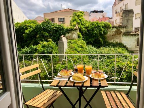 a table with food and drinks on a balcony at Modern City Center Apartment in Torres Vedras