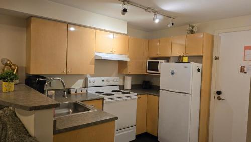 a kitchen with a white refrigerator and a sink at Lovely 1 Bedroom Condo in the Heart of Seattle! in Seattle