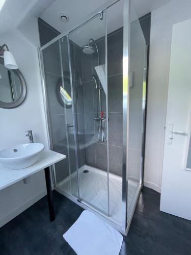 une salle de bain avec une douche en verre et un lavabo dans l'établissement Les Chambres de Souverain Moulin, à Pernes-lès-Boulogne