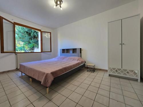 une chambre avec un grand lit et une fenêtre dans l'établissement Maison avec jardin et garage, à Carcassonne