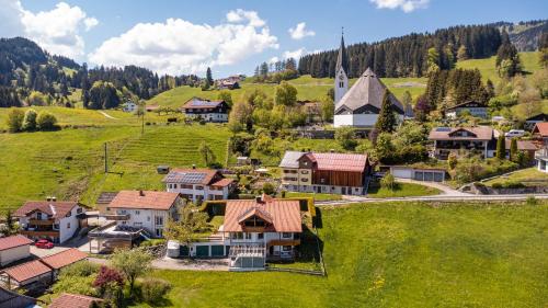 an aerial view of a small village with a church at Luxus Chalet im Allgäu - Zirbenholz Schlafzimmer - Terrasse mit Bergblick - Infrarotkabine in Blaichach