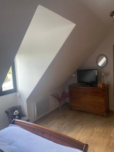 a bedroom with a bed and a tv on a dresser at Chambre des Tours 2 in Mont-Saint-Éloi