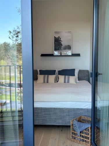 a bedroom with a bed and a glass door at Albatross 949 by the Sea in Ķesterciems